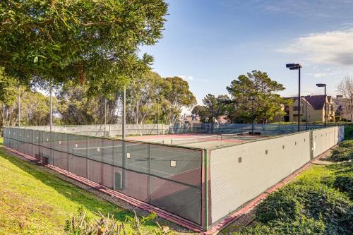 a tennis court in a park with two tennis rackets at Stay and Play Bay Area Condo with Community Pool! in Richmond