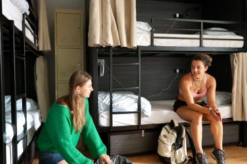 two girls in a dorm room with bunk beds at Ritz For Backpackers in Melbourne