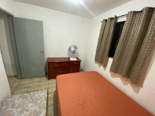 a bedroom with a bed and a window with a fan at Chácara Andorinhas São Pedro SP in São Pedro