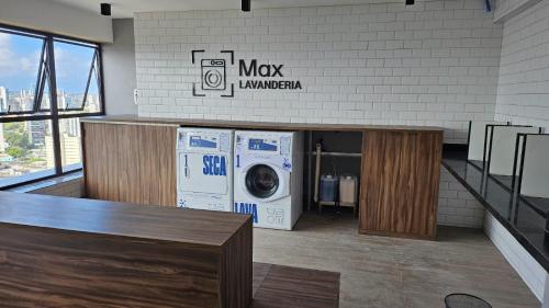 a laundry room with a washer and a washing machine at Loft Alto Padrão Um Quarto in Recife