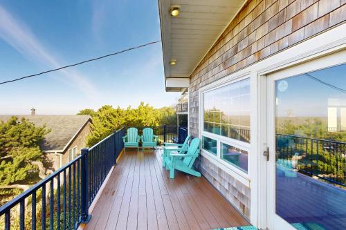 a balcony with chairs and tables on a house at Pacific Hideaway in Rockaway Beach