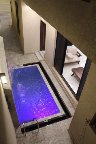 an overhead view of a blue tub in a bathroom at فيلا مكونة من 3 غرف نوم و مجلس و صالة و مطبخ وغرفة عاملة و مسبح تفتح الغرف حسب عدد النزلاء in Riyadh