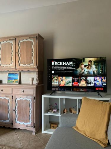 a living room with a couch and a flat screen tv at Nerinalia Residence in Áyioi Apóstoloi
