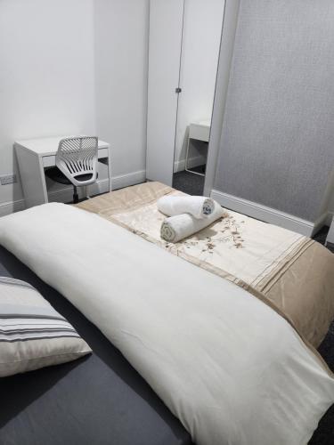 a bedroom with two beds and a chair at Manor House 002 in Walsall