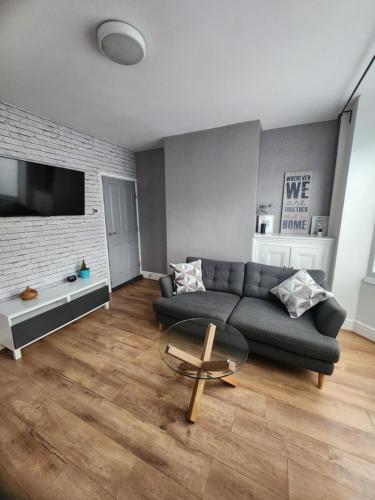 a living room with a couch and a table at Manor House 002 in Walsall