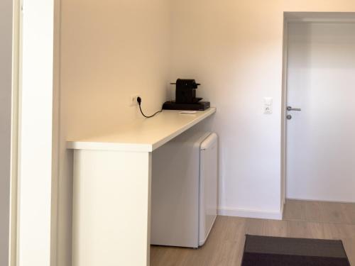 a small white counter in a room with a door at Modernes Studio-Apartment in Amstetten - Ideal für paare und Alleinreisende! in Amstetten
