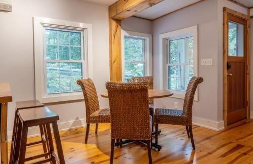 a dining room with a table and chairs and windows at Chic Farmhouse Woodstock Saugerties Skiing HITS in Saugerties