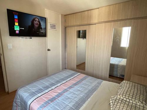 a bedroom with a bed and a flat screen tv at Hermoso departamento totalmente amoblado - Lte San Miguel in Lima