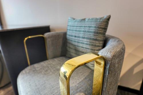 a gold chair with a pillow on top of it at Marsden Suites Albany in Albany