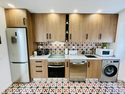 a kitchen with a refrigerator and a washer at Casa da Mostardeira in Évora