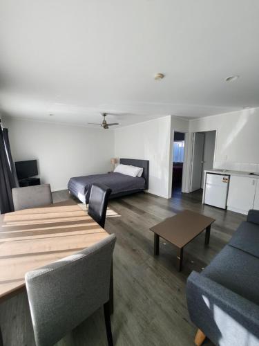 a living room with two couches and a table at Gardena Court Motel in Hamilton