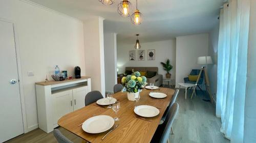 a dining room table with plates and flowers on it at Apartamento Verde Atlântico in Ponta Delgada