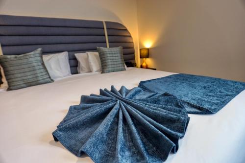 a large bed with a blue dress on it at Marsden Suites Albany in Albany