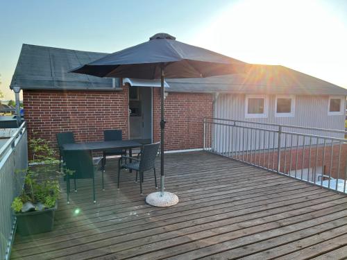an umbrella on a deck with a table and chairs at Garis Pension in Wesseln in Wesseln