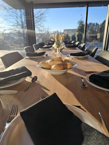 a long wooden table with a plate of bread on it at Domaine de l'Ambassadeur in Léglise