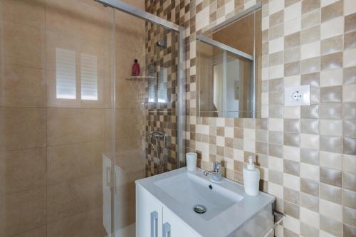 a bathroom with a sink and a shower with a mirror at Casa Moisés Brisa in Cádiz