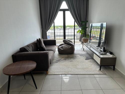 a living room with a couch and a television at B3A-5 Suites in Papar
