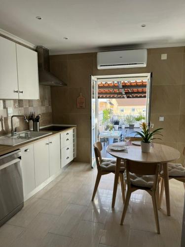 a kitchen with a table and chairs and a table and a table at Moradia aconchegante in Póvoa de Santa Iria