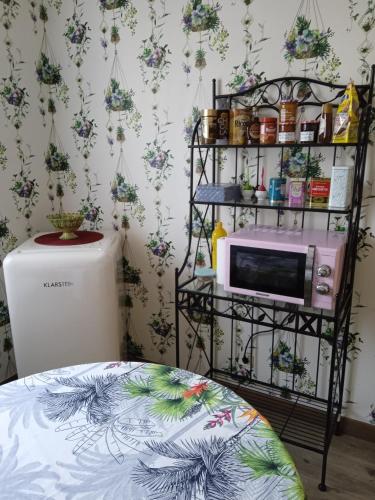 une pièce avec un micro-ondes sur une étagère dans l'établissement Chambre d'hôtes LA BELLE SAISON, à Villedômer