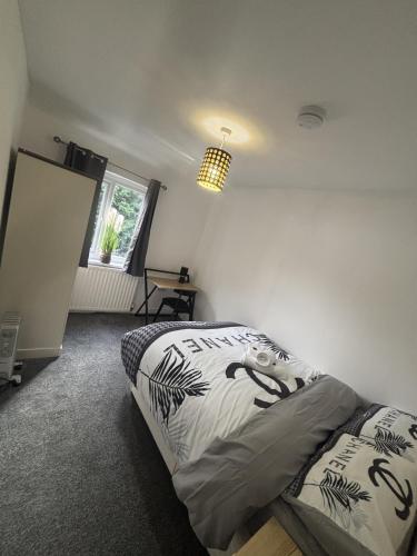 a bedroom with a bed and a chandelier at Cosy Charming room in big house in Little Hulton