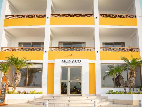a yellow building with palm trees in front of it at Monaco Chicama Beach in Puerto Chicama
