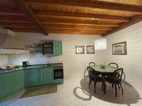 a kitchen with green cabinets and a table with chairs at Scrigno di Buranco in Monterosso al Mare
