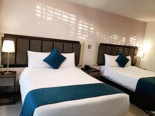 a hotel room with two beds with blue pillows at Hotel D'Carlo Class in Arequipa