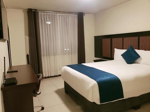 a hotel room with a bed and a desk and a bed sidx sidx at Hotel D'Carlo Class in Arequipa