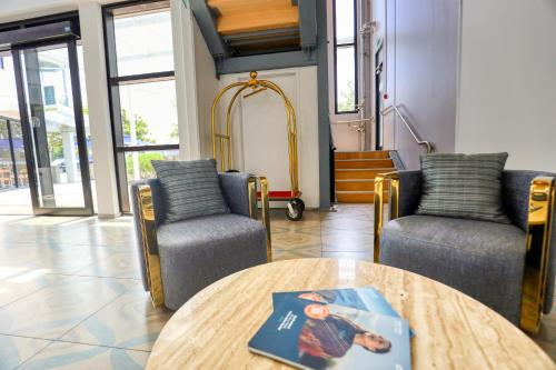 a room with two chairs and a table with a book on it at Marsden Suites Albany in Albany