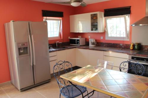 cocina con nevera blanca y mesa con sillas en Villa Carpe Diem, en Le Lavandou