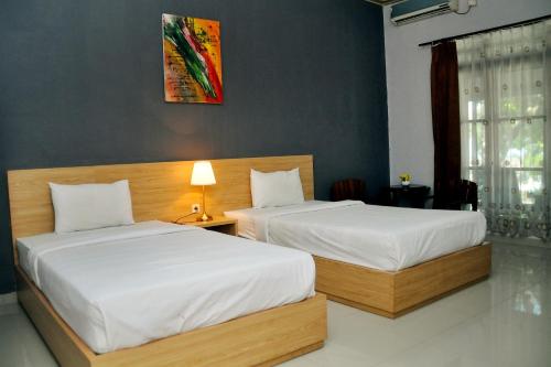 Postel nebo postele na pokoji v ubytování Purnama Mulia Hotel