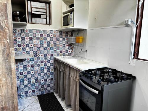 a small kitchen with a stove and a sink at Centro histórico Diamantina in Diamantina