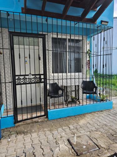 an iron gate with two chairs inside of a building at Apartamento Costa Azul en El Pueblito in San Felipe de Puerto Plata
