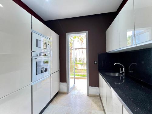 a kitchen with black and white cabinets and a sink at Ritz carlton luxurious stay in Marina Smir