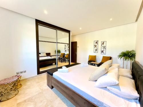 a bedroom with a large bed and a living room at Ritz carlton luxurious stay in Marina Smir