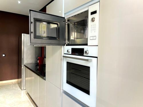 a kitchen with a microwave and an oven at Ritz carlton luxurious stay in Marina Smir