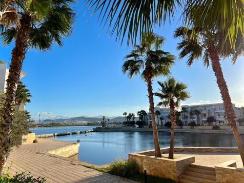 a view of a river with palm trees and buildings at Ritz carlton luxurious stay in Marina Smir
