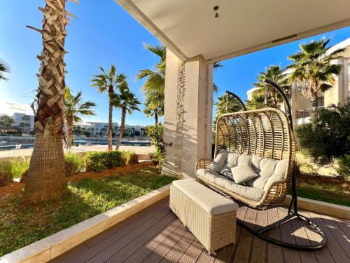a wicker chair on a porch with a view of the ocean at Ritz carlton luxurious stay in Marina Smir