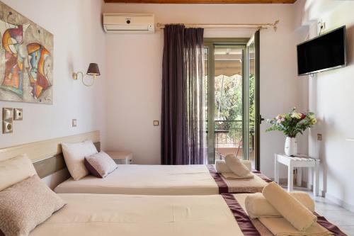 Una habitación de hotel con dos camas y un televisor. en Nontas Homes 35, en Kalamitsi