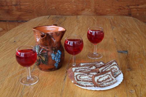 three wine glasses and a vase on a wooden table at Holiday home in Otocec - Kranjska (Krain) 33898 in Otočec