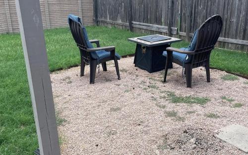 two chairs and a table in a yard at New Home with King Bed and 3 Bedrooms Fire-pit Minutes to Cota and Tesla in Austin