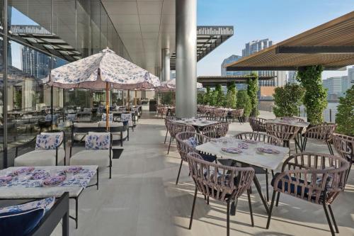 an outdoor patio with tables and chairs and umbrellas at The St. Regis Downtown Dubai in Dubai