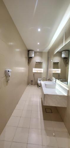 a bathroom with a large white sink and a mirror at سارة للأجنحة الفندقية in Al Kharj