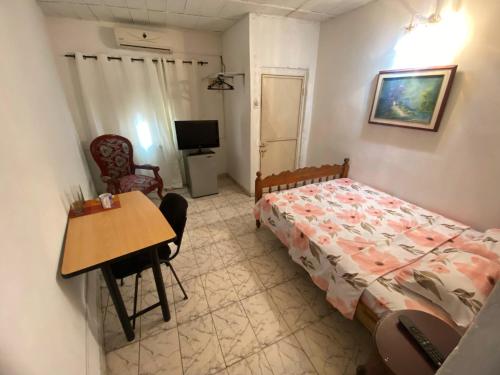 Un dormitorio con una cama, una mesa y un escritorio. en Perez Leal, en San Antonio del Táchira