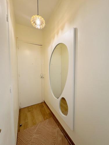 un couloir avec un miroir mural dans l'établissement Chic Cosy Calm - Monparnasse, à Paris