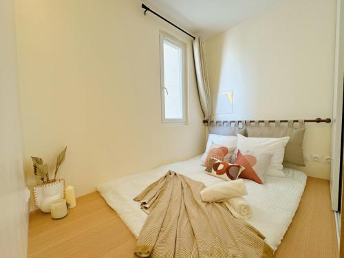 une chambre avec un lit blanc avec une fenêtre dans l'établissement Chic Cosy Calm - Monparnasse, à Paris