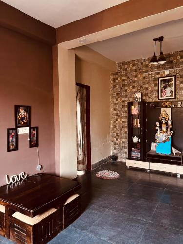 a living room with a pool table and a brick wall at Alipur Abode in Kolkata