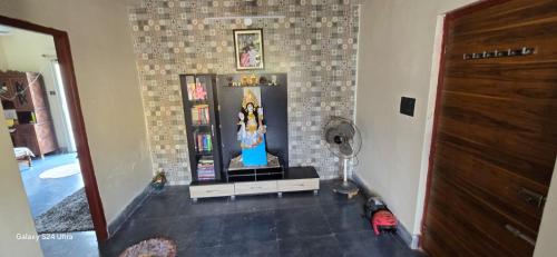 a living room with a tv and a brick wall at Alipur Abode in Kolkata
