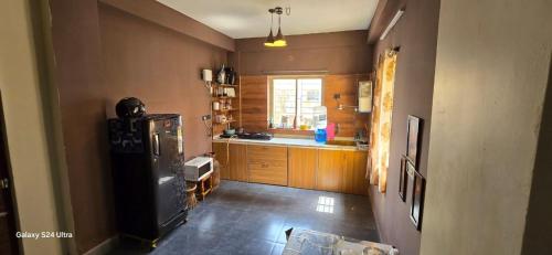 a kitchen with a refrigerator and a window in it at Alipur Abode in Kolkata