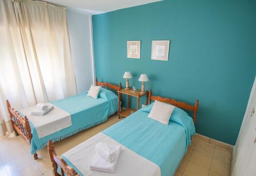 zwei Betten in einem Zimmer mit blauen Wänden in der Unterkunft Depto. Alvear 972 in San Salvador de Jujuy